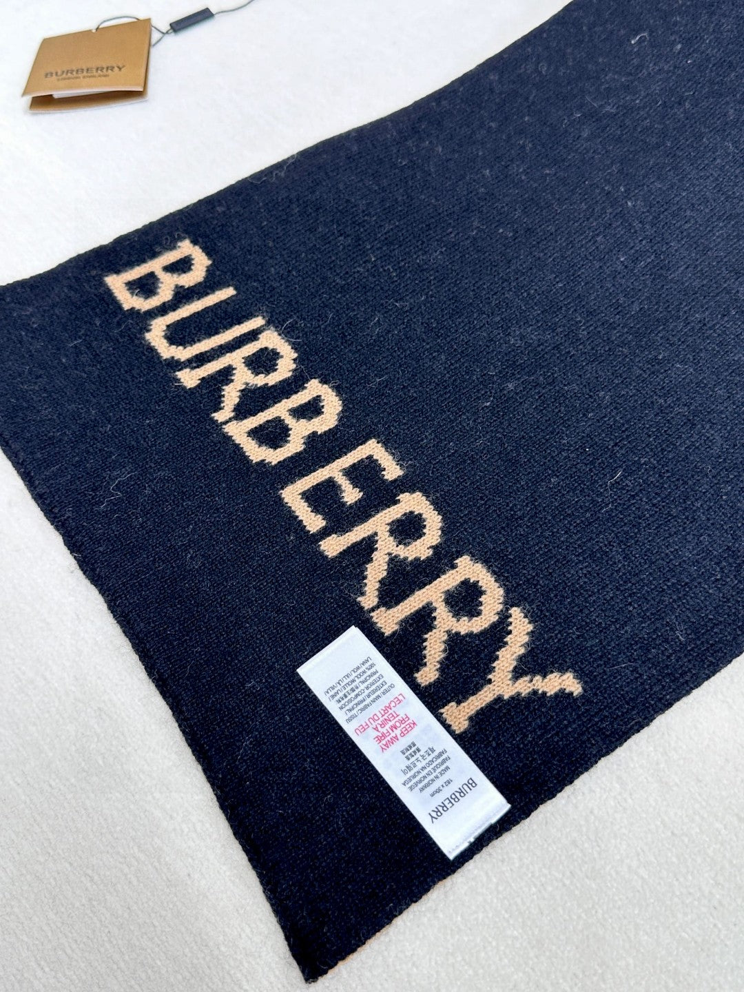 Burberry reversible two-tone wool scarf featuring a circular logo design, crafted from a cotton-wool blend